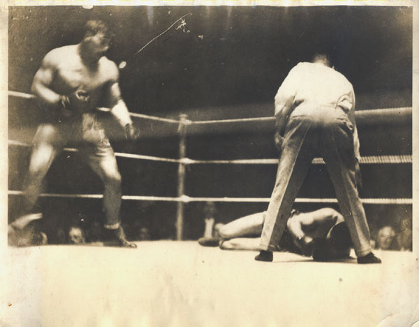 A hulking Primo Carnera stands over Stribling in the third round of their 1929 clash, which likely was not on the level.